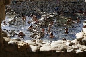 Personas en los baños termales del pantano de Yesa. EFE/Jesús Diges