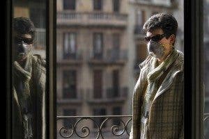 Una mujer afectada con el síndrome de sensibilidad química múltiple en su casa y tapada con mascarilla
