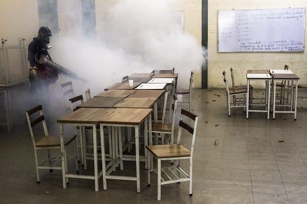 Un trabajador fumiga una escuela pública durante una jornada de saneamiento ambiental y fumigación contra los virus del dengue y la chinkunguña en Caracas (Venezuela). Efesalud.com