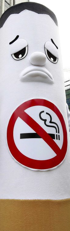 Un muñeco que representa un cigarrillo con cara triste quiere que dejemos de fumar con un prohibido dibujado en su cuerpo de papel y tabaco.
