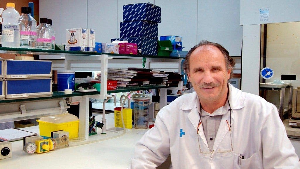 El profesor Francisco Guarner posa sentado a la mesa de un laboratorio