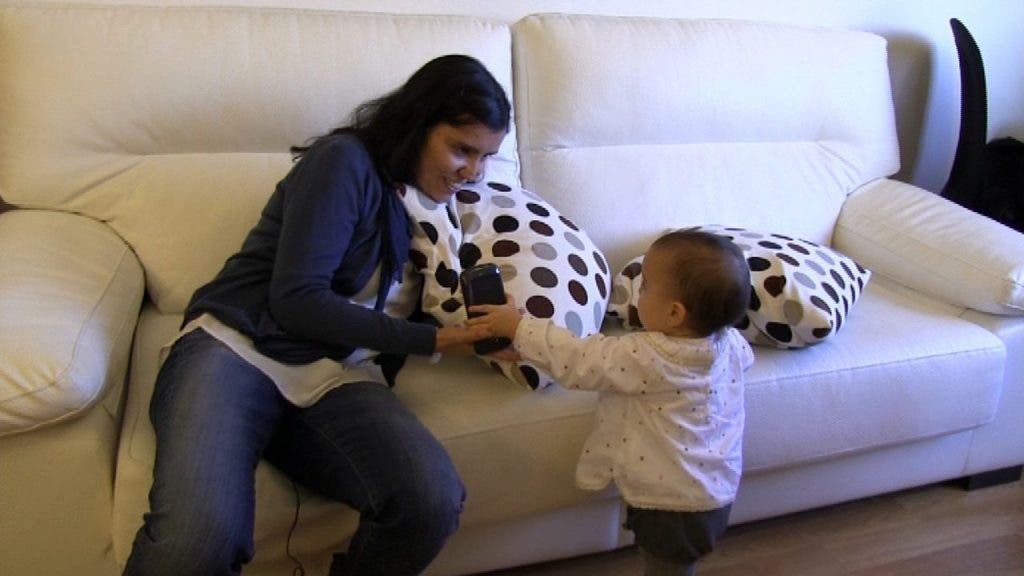 La mamá pediatra, María Salmerón, juega con su hija Julia en el tresillo de su casa.