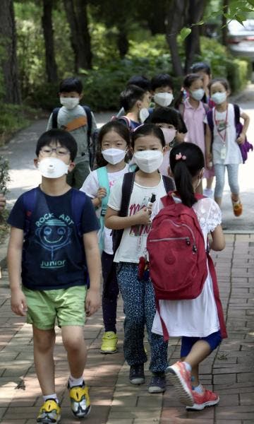Escolares con mascarillas camina a casa tras ir a clase en Seúl. Efesalud.com