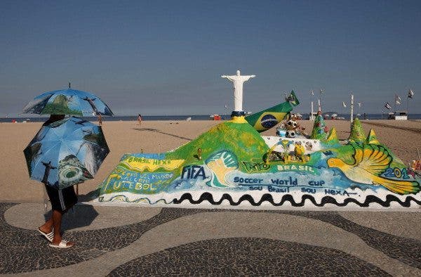 Persona con paraguas pasea por el paseo marítimo de una ciudad Brasileña. Efesalud.com