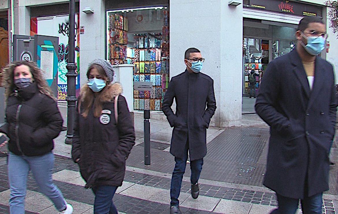 Dos mujeres y dos hombres cruzan un paso de cebra en direcciones opuestas