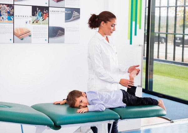 La podóloga estudiando los trastornos menores de los pies de un niño. 