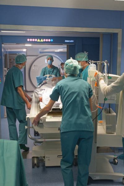 Los equipos médicos acompañan al paciente a comprobar la eficacia de la neurocirugía en el equipo de la resonancia magnética de 3 Tesla.