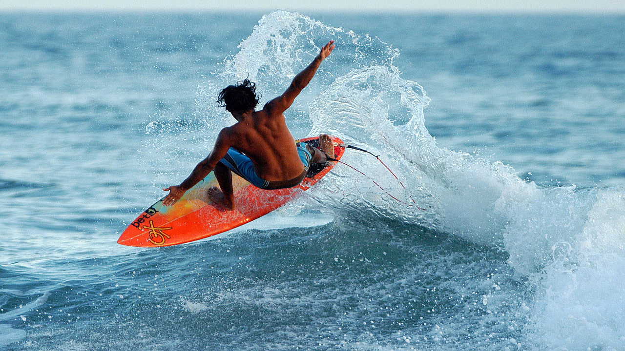 Un surfista realiza acrobacias sobre las olas en las playas de la costa de La Libertad a unos 25 kilómetros al sur de San Salvador