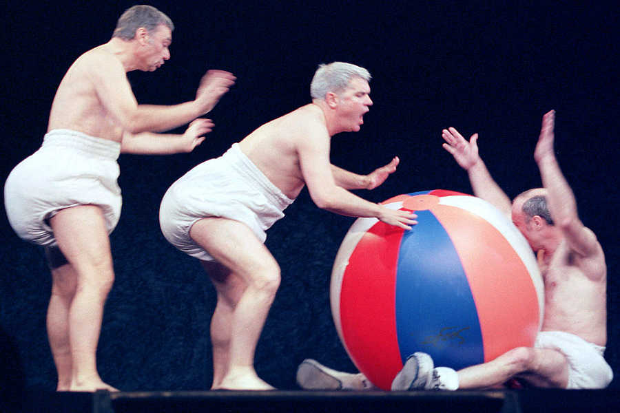 Los componentes de Tricicle, grupo de tres mimos, en su actuación con pañales y una gran pelota de playa.