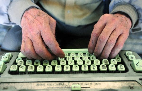 Las manos de una persona mayor teclean una vieja máquina de escribir. Efesalud.com