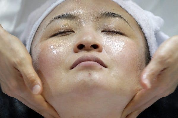 Primer plano del rostro de una mujer que recibe un masaje facial. Efeslaud.com