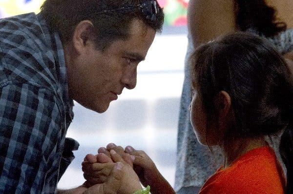 Un padre mira a su hija mientras agarra sus manos. Efesalud.com