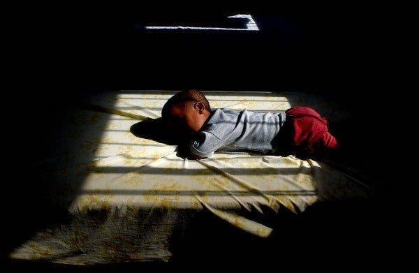 Un niño reposa sobre una cama en contraluz. Efesalud.com