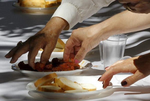 Varias manos toman comida de un plato. Efesalud.com