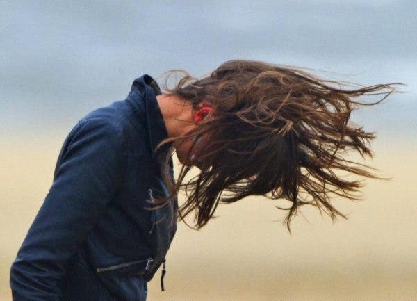 Una chica lucha contra el viento para controlar su melena. Efesalud.com