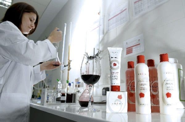 Una técnica en investigación trabaja con vino en el laboratorio. Efesalud.com